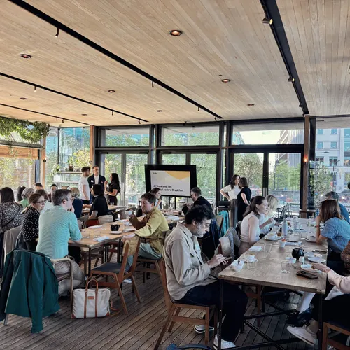 Attendees from the Torchbox AI Show and Tell event seated at tables in a bright, airy venue.