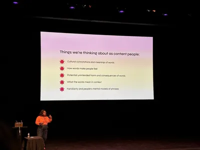 Content designer Candi Williams presents on stage at Camp Digital beside a slide titled “Things we’re thinking about as content people,” covering language, meaning and the impact of words in digital content.