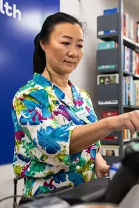 A person working at a till in a charity shop.