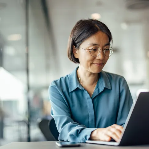 Woman smiling at laptop finance corporate