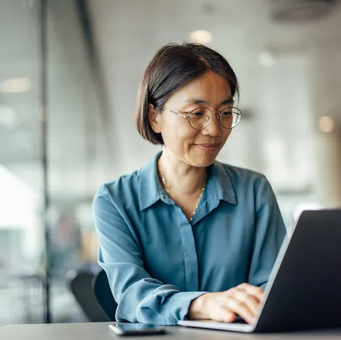 Woman smiling at laptop finance corporate