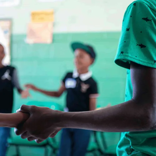 Children holding hands together in school setting