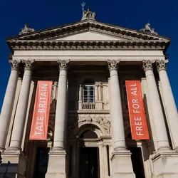 An exterior shot of the Tate Britain with a blue sky.